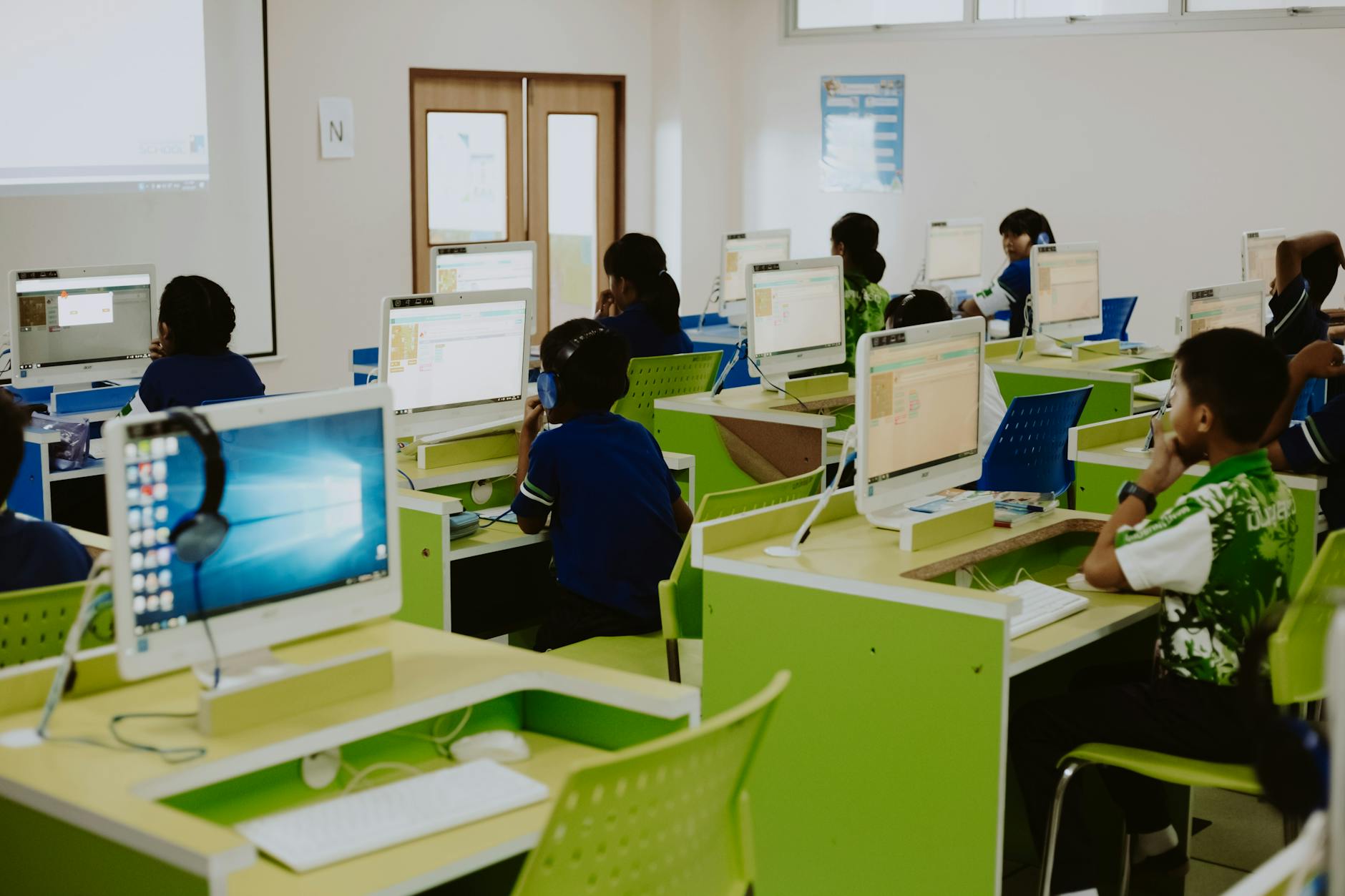 Children in school computer lab using computers for education and digital learning.