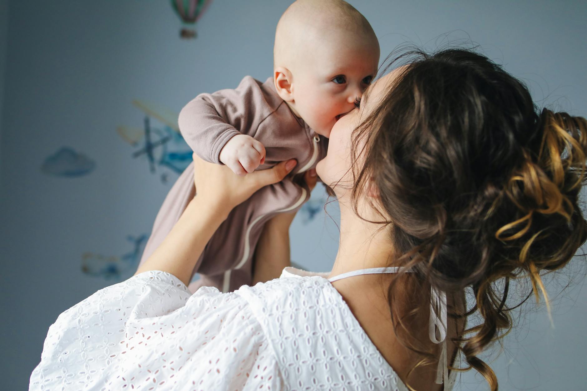 Mother kissing her baby, symbolizing postpartum brain changes, maternal bonding, and emotional connection after childbirth.