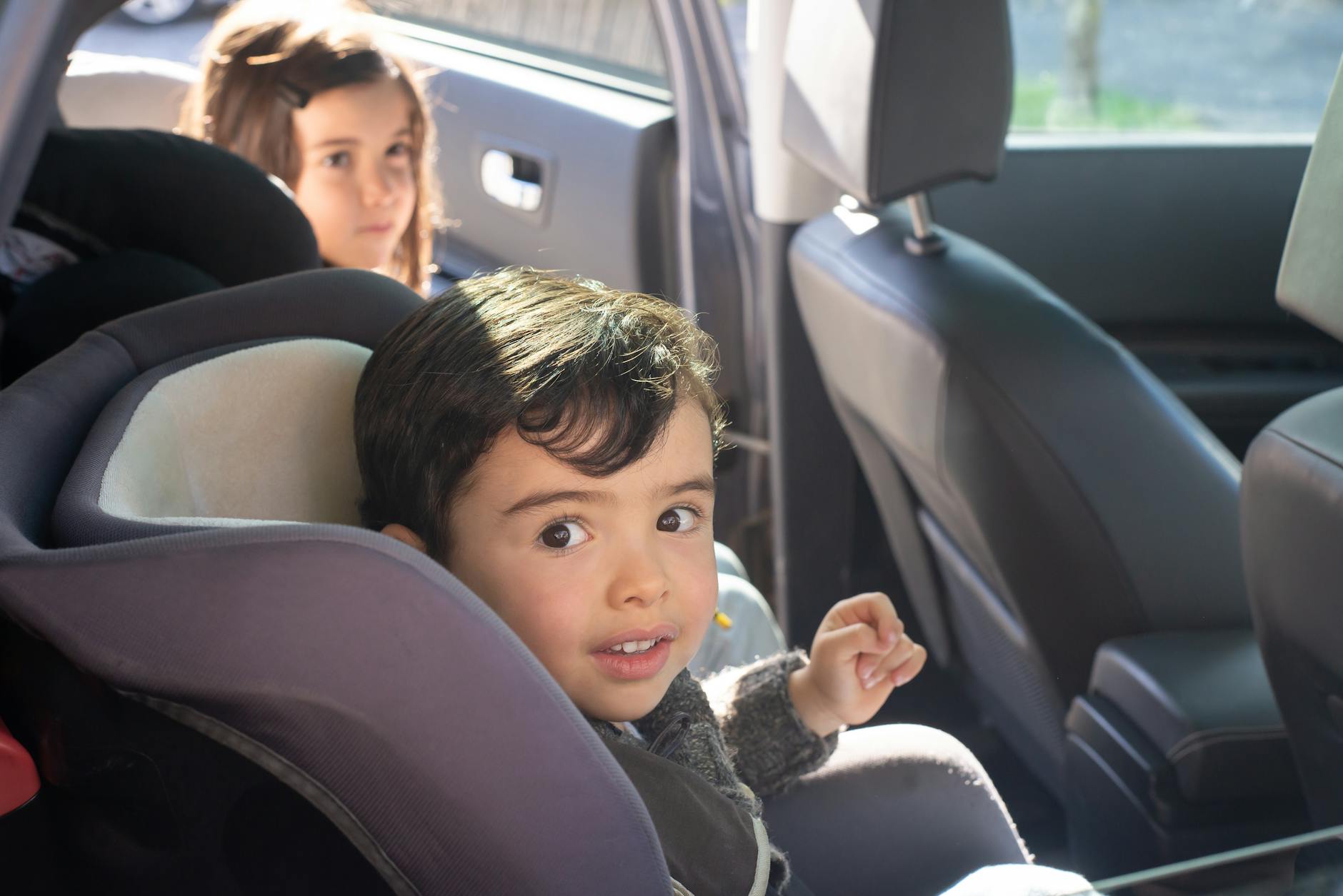 Child sitting safely in a car seat during an overnight family road trip