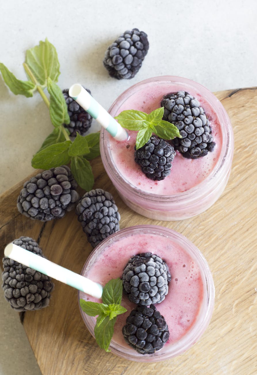 Strawberry smoothie in a glass topped with fresh blueberries