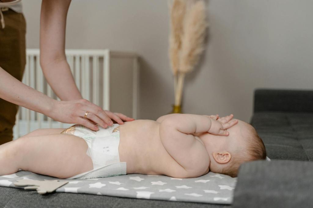 Parent changing a baby’s disposable diaper at home, showing the reality of hybrid diapering alongside cloth diapers.