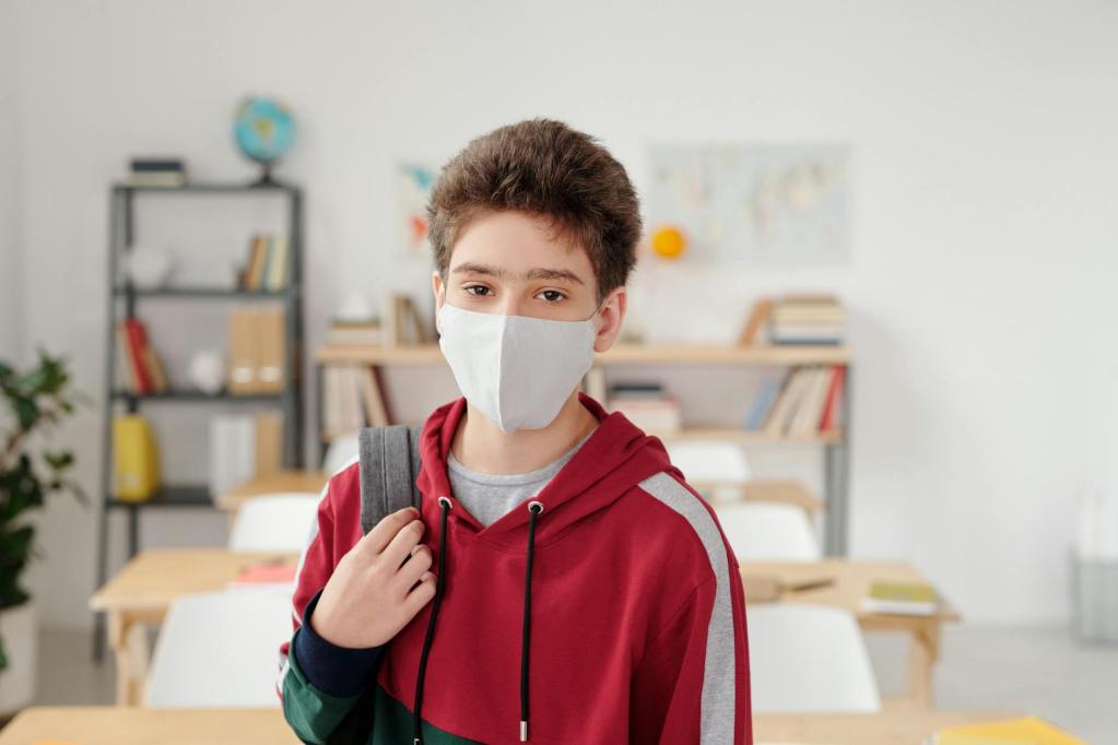Elementary school boy in hoodie with face mask