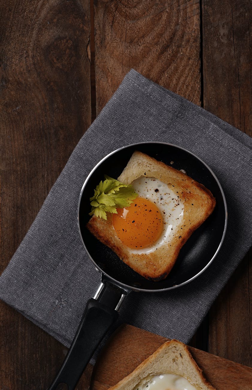 Egg in a hole toast with a cooked egg in the center of a slice of bread, served as a quick and easy snack for kids