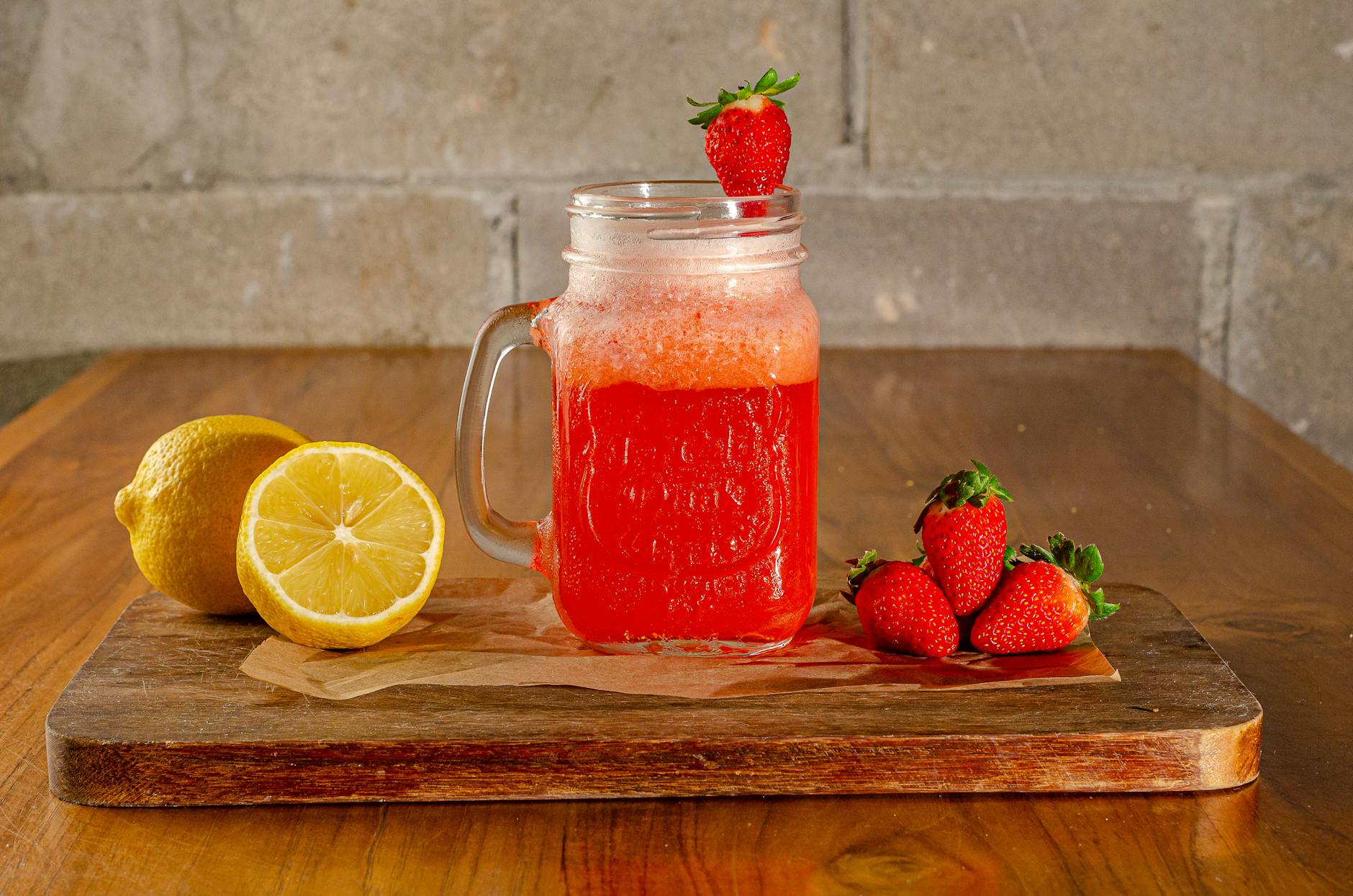 Strawberry and lemon summer drink with ice cubes served as a healthy kids cooler